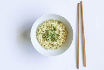 Noodles in bowl with chopsticks isolated on white