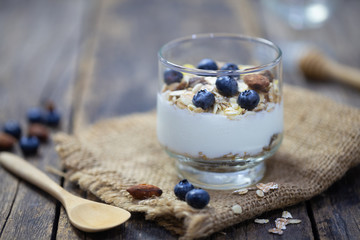 homemade Granola with yogurt and fresh blueberry In a glass on wooden background