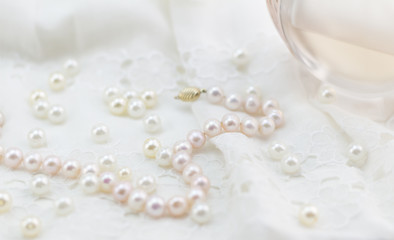 Pearls, lace and perfume soft focus photo white and pink background