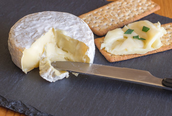 Camembert cheese and crackers on cheese slate board