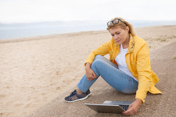 Woman on a beach with her laptop