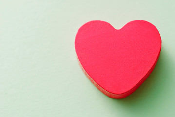 Fototapeta premium Red heart on a green background, top view