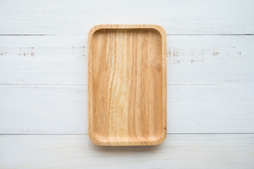Top view of unused brand new brown handmade wooden dish plate on white wooden table background