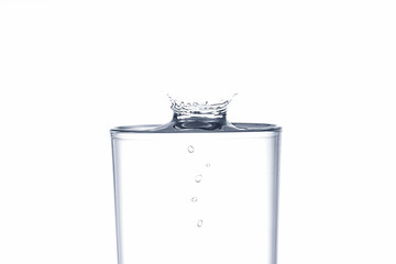 Water drop splash on drinking glass on white background