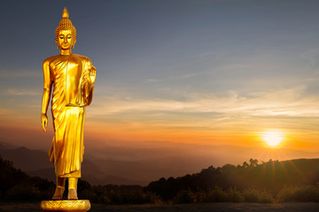Statue dorée de Bouddha sur fond de lever de soleil