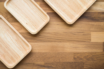 Top view of unused brand new brown handmade wooden kitchen utensil, dish plate on wooden table background