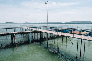 Obraz premium Wooden pedestrian path over sea surface with beautiful view of Ao Khung Kraben bay at Sea Fish Farming Demonstration Unit, Royal Project, Ta Mai District, Chanthaburi.