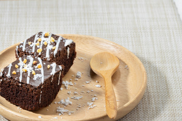 Two chocolate brownies and spoon On a plate of wood