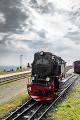 Black locomotive with red color driving on a railtrack