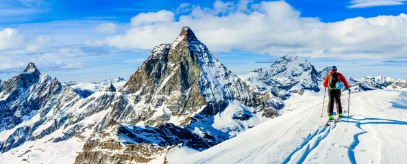 Photo sur Aluminium Sports dhiver Homme skiant sur la poudreuse fraîche. Ski en hiver, montagnes et équipements de ski de randonnée dans l& 39 arrière-pays au sommet des montagnes enneigées par beau temps avec le Cervin en arrière-plan, Zermatt dans les Alpes suisses.