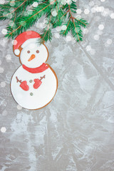 Greeting card with decorative gingerbread, spruce branch and gift boxes on a gray cement background. Overhead of christmas new year background. View from above. Copy space