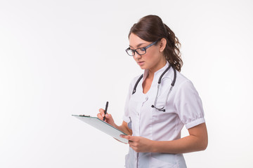 Medicine, health and treatment concept - Happy smiling doctor writing on clipboard, isolated on white background