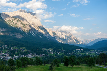 Fototapeta na wymiar Mountain slopes along the shoreline of Lake Misurina, in the Italian Dolomites, on a Summer's Afternoon.