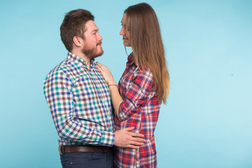 Portrait of cheerful laughing funny young lovers fooling around on blue background