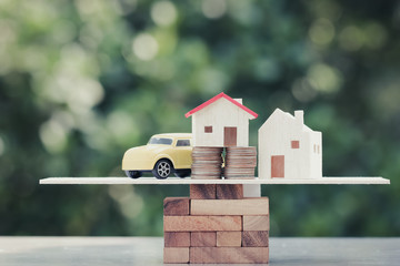 Business real estate investment concept : Wooden home, car with stack of money coins on wooden...