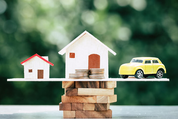 Business real estate investment concept : Wooden home, car with stack of money coins on wooden...