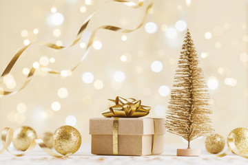 Christmas gift box against golden bokeh background. Holiday greeting card.