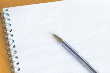 the pen is on an empty notebook