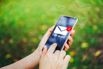 Woman hand using smartphone to send and recieve email.