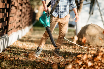 Gardening details - professional landscaper using leaf blower