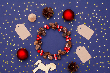 Christmas new year layout of wooden objects, sequins, decorative ornaments and a wreath of cones