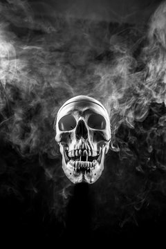 Front of real skull in abstract smoke isolated on black background.