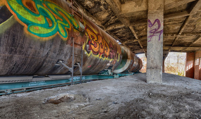 Old rusty fuel tank train inside old abandoned station with graffity on it. HDR panoramic image