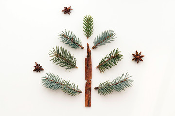 Christmas concept. Christmas tree made from fir branches, cinnamon and anise stars on white background. Flat lay, top view