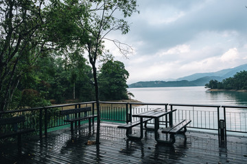 Chairs on a deck overlooking a lake after the rain at sun moon lake in Taiwan