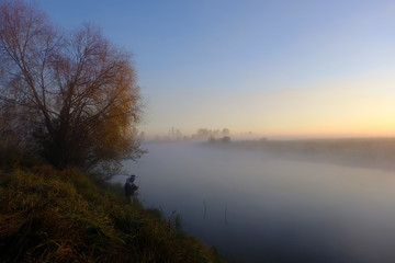 Fototapeta na wymiar fog over the river and fisherman