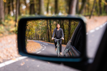 Cycling male in car rearview mirror