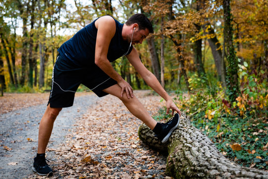 Fit male stretching in forest
