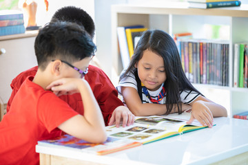 students are reading book in library room school