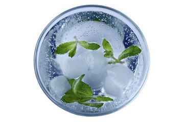 A refreshing summer drink with ice and mint in the glass with air bubbles in mineral water. Blue...