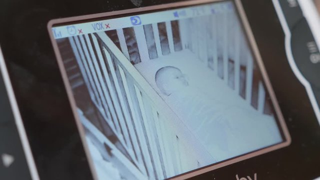 A Baby Monitor With Newborn Girl Sleeping In Her Crib