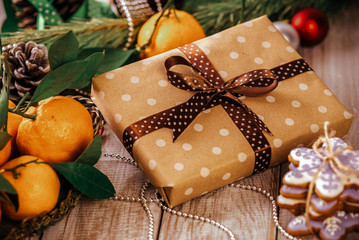 Christmas composition - present box and gingerbread cookie, anise and cinnamon on wooden table