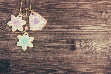 Gingerbread cookies hanging over wooden background. Copy space.