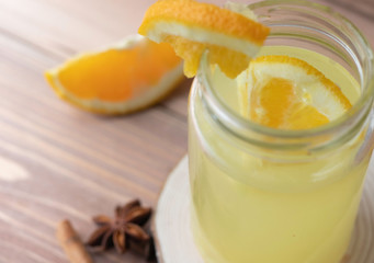 Cocktail on wood background. Cold citrus beverage with ginger, orange, lemon