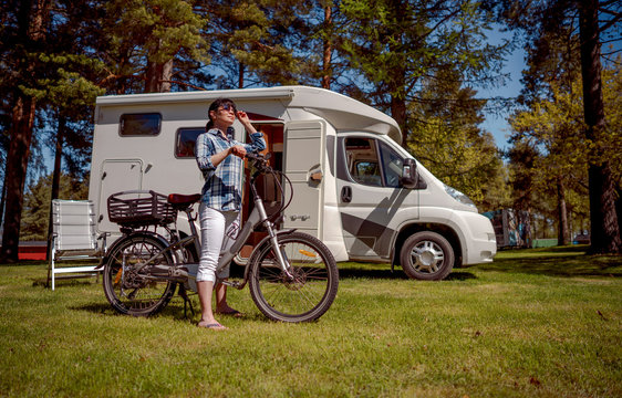 Woman on electric bike resting at the campsite VR Caravan car Vacation.