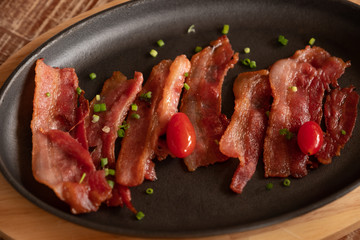 Grilled bacon, tomato and herb served on black pan plate