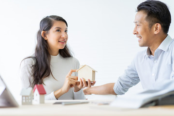 Happy couple plan buying house.Concept for Couple saving money for buy home and real estate. Select material for decorate furniture.