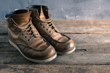 brown vintage leather boots on wooden background