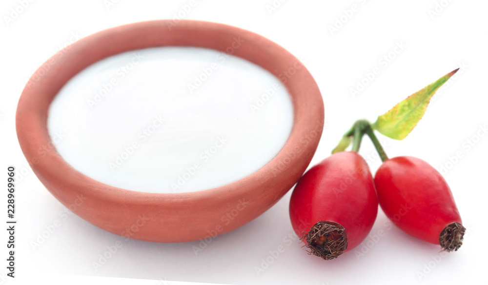 Poster rose hips with fresh milk in a pottery