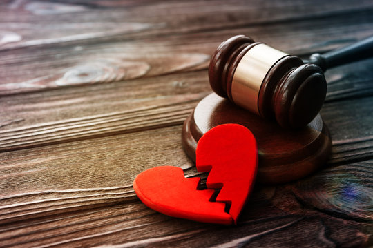 heart, judge's gavel on the background of a wooden table. divorce and conflict, family law. property division.