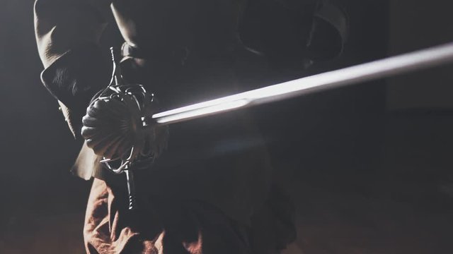 Medieval warrior with sword indoors in slow motion. Close up