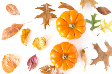 Pumpkins with autumn leaves isolated on white background. Overhead view.