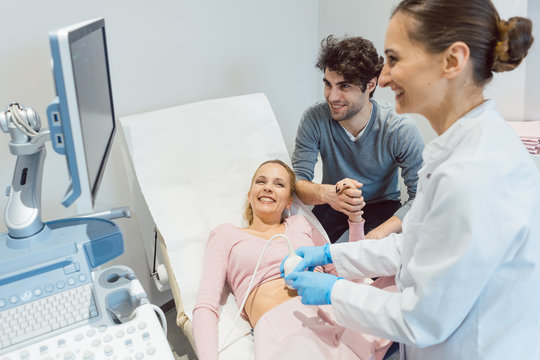 Couple in reproduction clinic being happy as the wife is pregnant as revealed by ultrasonic examination 
