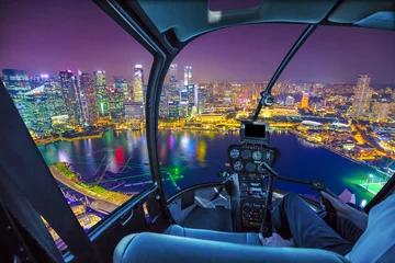 Rolgordijnen Schilderachtige helikoptervlucht boven de skyline van Singapore bij dageraad. Nacht stedelijke luchtfoto. cockpitbinnenland met financiële districtswolkenkrabbers bij nacht op de haven van Singapore. © bennymarty