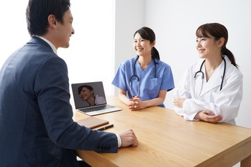 Fototapeta premium 営業する男性ビジネスマン 女性医師と看護師