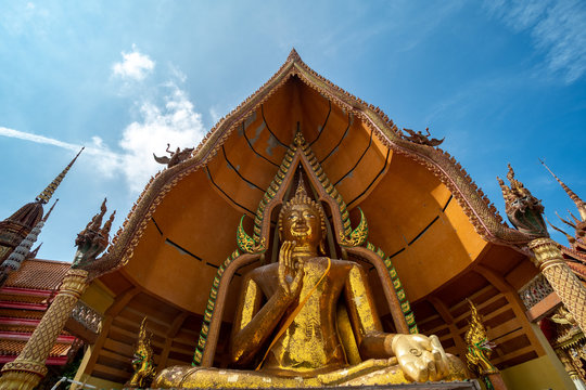 Big golden Buddha in Wat Tham Suea,Kanchanaburi. The thai temple in rice field.